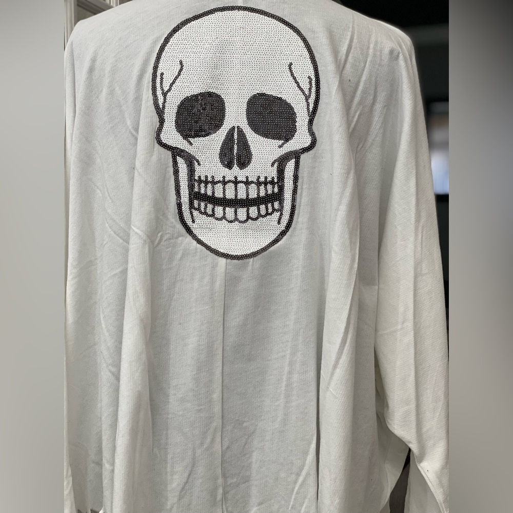 High low fringe long sleeve shirt with a sequin skull on the back